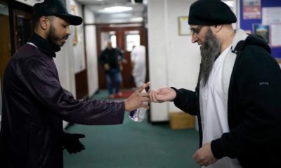 A volunteer dispenses hand sanitiser to devotees attending Friday prayers at Birmingham Central Mosque on March 13 2020 in Birmingham England