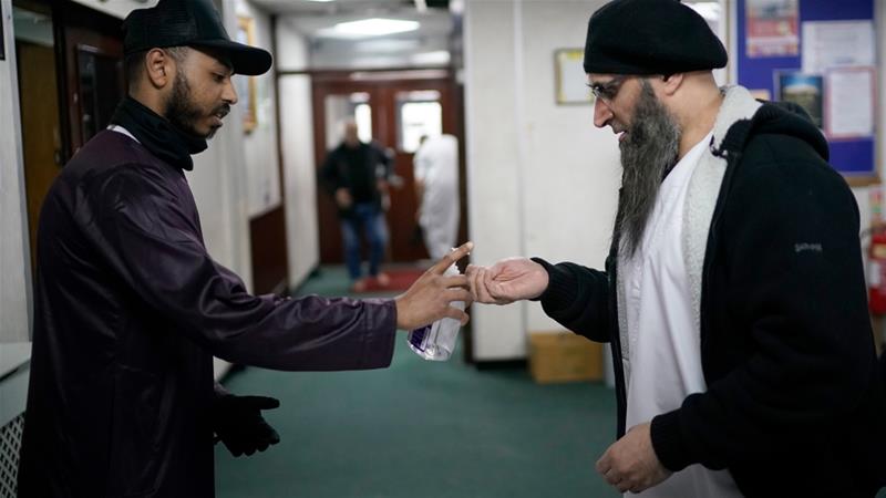 A volunteer dispenses hand sanitiser to devotees attending Friday prayers at Birmingham Central Mosque on March 13 2020 in Birmingham England