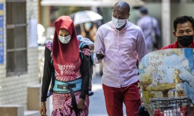 An African couple wearing masks walk in the African Village part of Guangzhou Guangdong province China on 29 April 2020