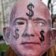An activist holds up a mask depicting Amazon founder Jeff Bezos during a protest against the opening of a new Amazon office in Berlin Germany on February 22 2020
