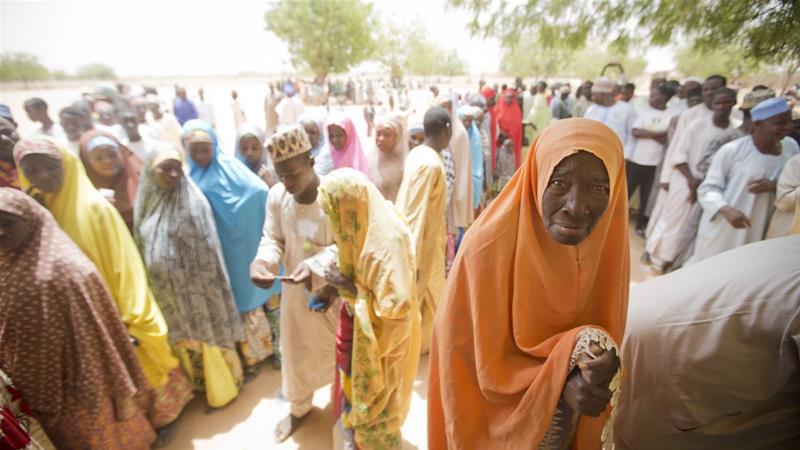 An elderly Nigerian woman stands in the shade while waiting to cast her vote at a polling station in Daura northern Nigeria on March 28 2015
