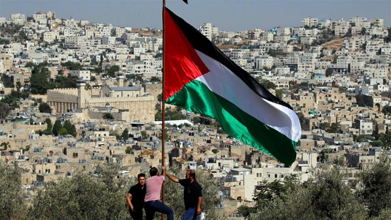 Demonstrators place a Palestinian flag during a protest against Israeli Prime Minister Benjamin Netanyahus visit to Hebron in the occupied West Bank September 4 2019