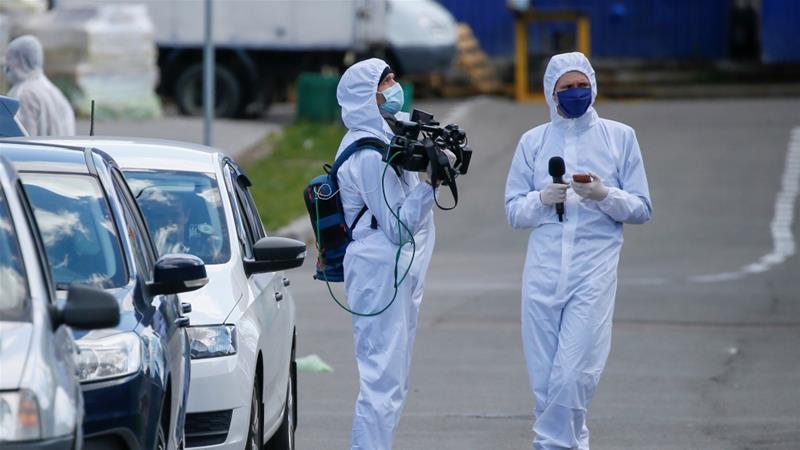 Journalists wearing protective gear wait near a hostel which was closed after residents reportedly tested positive for the coronavirus in Kiev Ukraine on April 28 2020