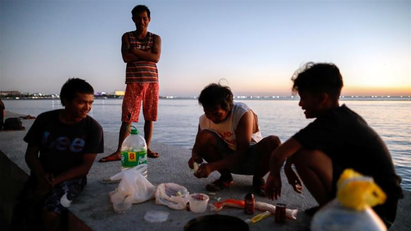 Some stranded and homeless Filipinos prepare dinner as they take shelter along Manila Bay following the announcement of a lockdown in Manila the Philippines in April 2020
