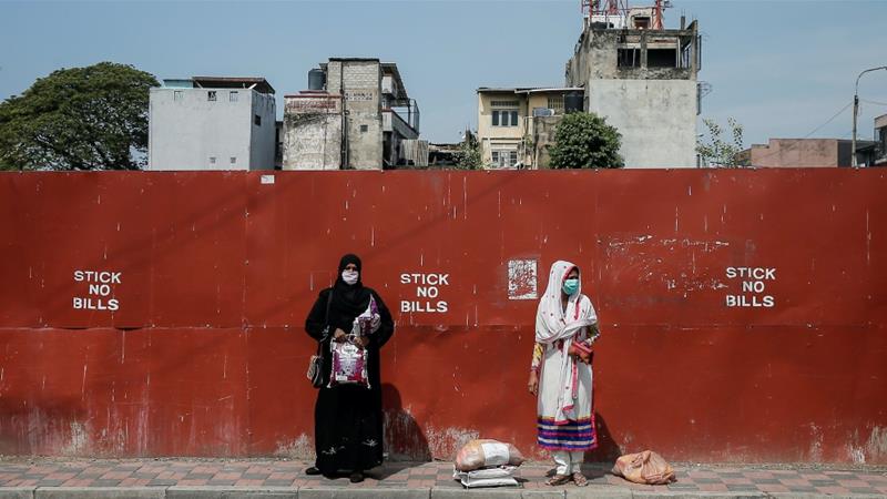 Two Muslim women wearing protective masks stand on a side of the main road in Colombo Sri Lanka April 1 2020