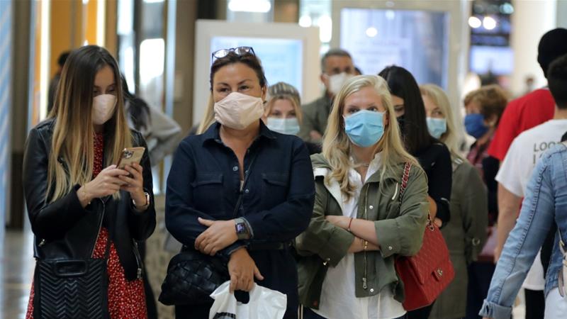 Women wearing protective face masks wait to enter in a shop in Saint Laurent du Var near Nice as France softens its strict lockdown rules May 11 2020