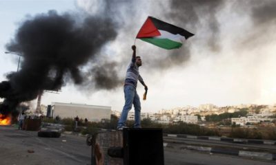 A Palestinian man waves the national flag during a protest against Israels operations in Gaza Strip near the West Bank city of Ramallah on Nov 18 2012