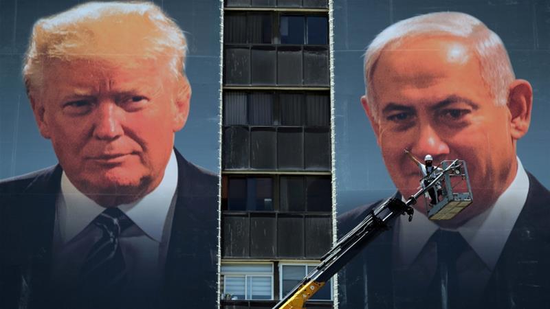 A labourer stands on a crane as he puts up banners depicting US President Donald Trump and Israeli Prime Minister Benjamin Netanyahu in Jerusalem on June 10 2020