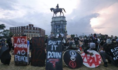 Black Lives Matter protesters wait for police action as they surround the statue of Confederate General Robert E Lee on Monument Avenue June 23 2020 in Richmond US