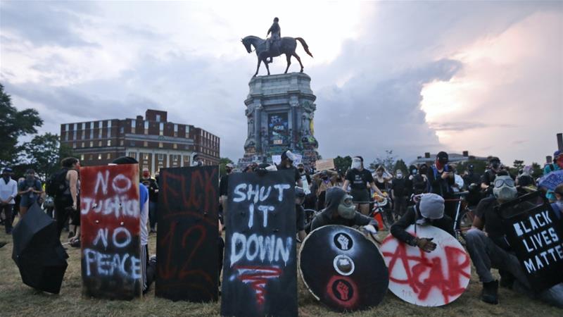 Black Lives Matter protesters wait for police action as they surround the statue of Confederate General Robert E Lee on Monument Avenue June 23 2020 in Richmond US