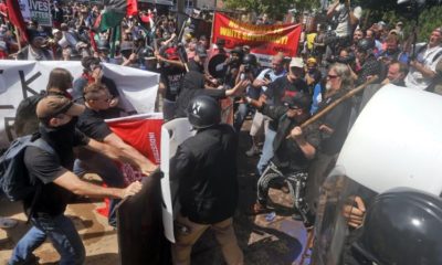 In this August 12 2017 file photo white nationalist demonstrators clash with counter demonstrators at the entrance to Lee Park in Charlottesville Va US
