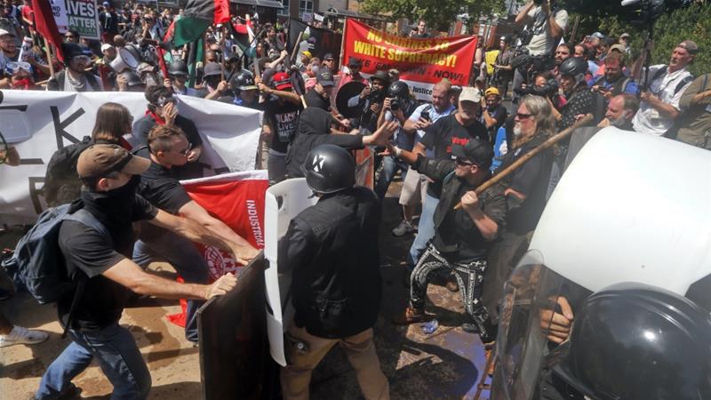 In this August 12 2017 file photo white nationalist demonstrators clash with counter demonstrators at the entrance to Lee Park in Charlottesville Va US