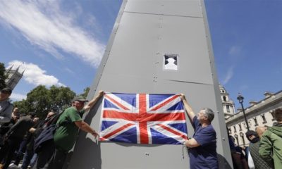 Members of far right Football Lads Alliance hold a British flag in front of the covered statue of Winston Churchill in Parliament Square London June 13 2020