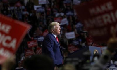 US President Donald Trump stands at the podium listening to his supporters cheer as he addresses his first campaign rally in months in Tulsa US on June 20 2020