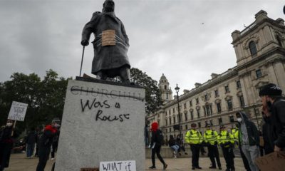 Protesters and police gather around the statue of Winston Churchill in Parliament Square during the Black Lives Matter protest rally in London Sunday June 7 2020
