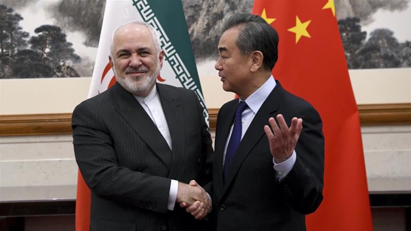 Chinas Foreign Minister Wang Yi shakes hands with his Iranian counterpart Mohammad Javad Zarif during a meeting in Beijing China on December 31 2019