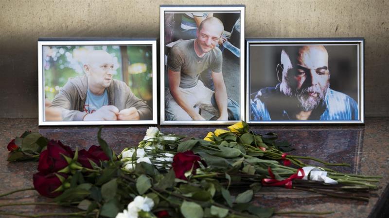 Flowers are placed by portraits of slain journalists Alexander Rastorguyev Kirill Radchenko and Orkhan Dzhemal at the Russian Journalists Union in Moscow on August 1 2018