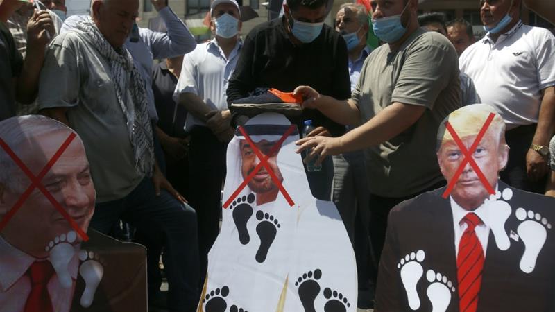 Palestinians place shoes on pictures of American Israeli and Emirati leaders during a protest against the UAEs deal with Israel in Nablus West Bank Aug 14 2020