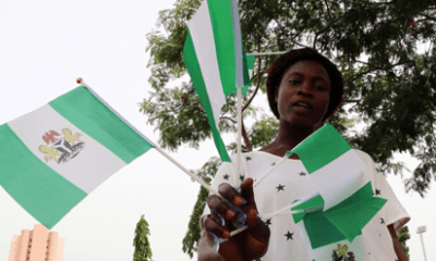 A Nigerian holding multiple Nigerian flags