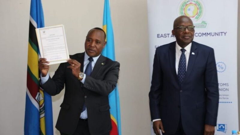 Secretary-General Paul Mathuki displays DRC document.
