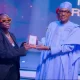 Buhari giving award to Teni