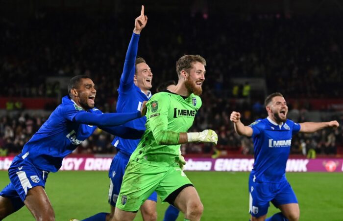 Gillingham's French striker Mikael Mandron (L) and Gillingham's English goalkeeper Jake Turner (C) after the English League Cup third round football match between Brentford and Gillingham at the Brentford Community Stadium in London on November 8, 2022. - Gillingham won the match 6-5 after a penalty shoot-out. (Photo by Glyn KIRK / AFP)