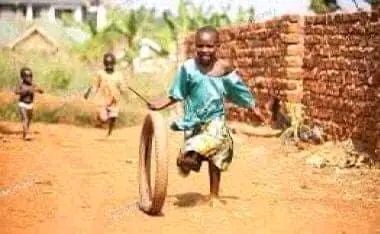 A Child playing with a motorcycle tyre
