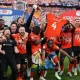 Luton Town’s players celebrate on the pitch after Luton win the penalty shoot-out in the English Championship play-off final football match between Coventry City and Luton Town at Wembley Stadium in London on May 27, 2023. – Luton won the game 6-5 on penalties after the game finished 1-1 after extra time. (Photo by ADRIAN DENNIS / AFP)