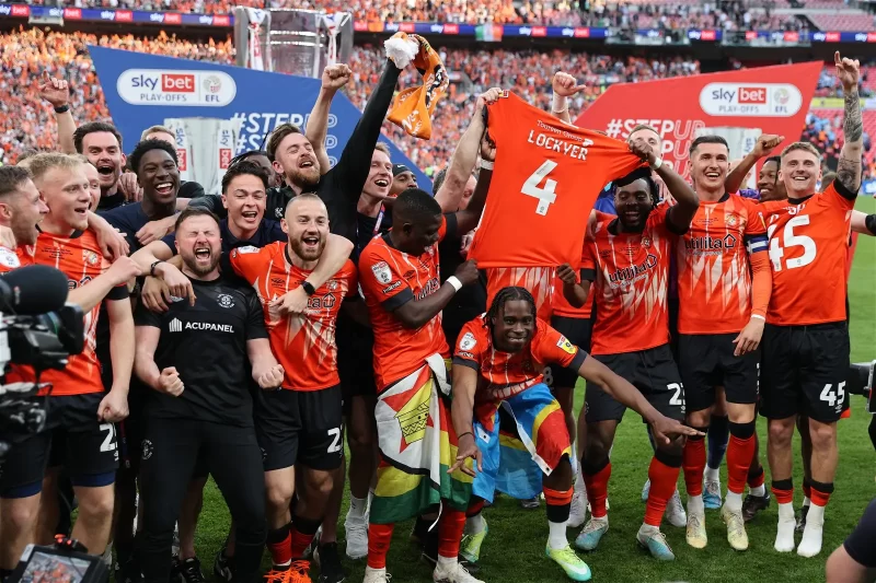 Luton Town’s players celebrate on the pitch after Luton win the penalty shoot-out in the English Championship play-off final football match between Coventry City and Luton Town at Wembley Stadium in London on May 27, 2023. – Luton won the game 6-5 on penalties after the game finished 1-1 after extra time. (Photo by ADRIAN DENNIS / AFP)