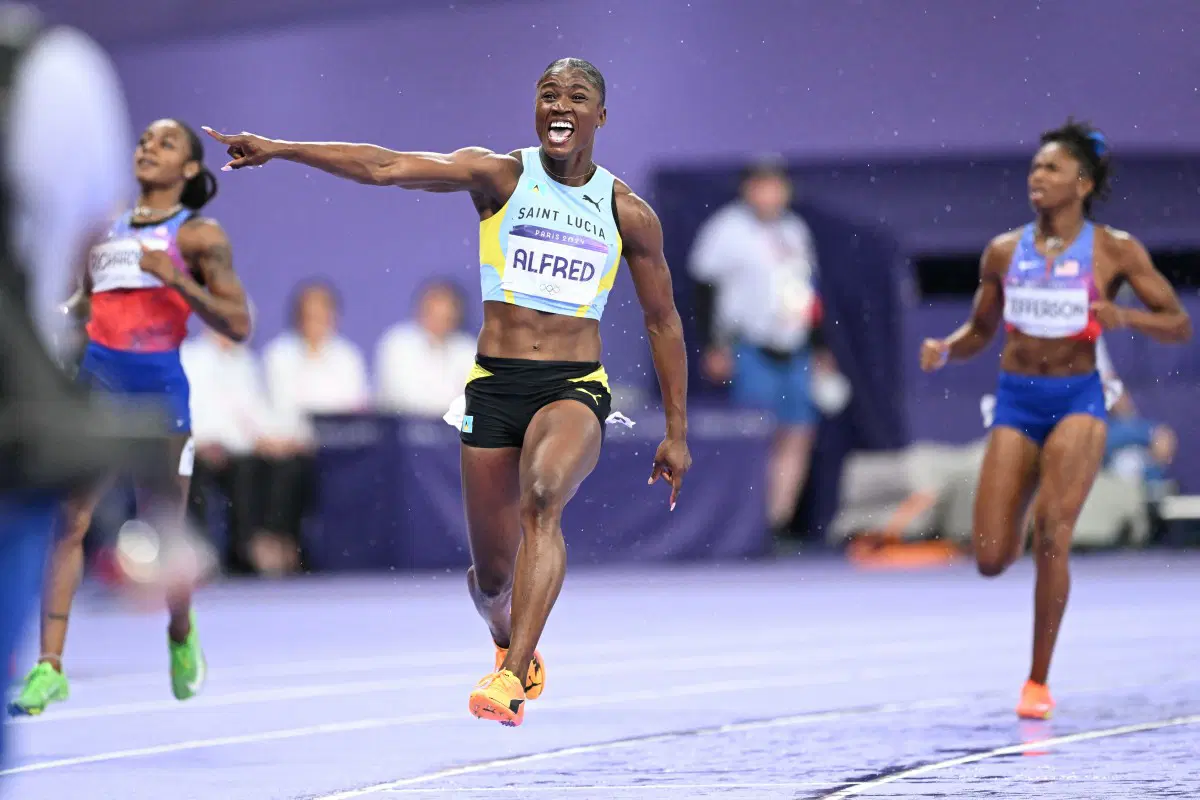 Saint Lucia’s Julien Alfred celebrates after winning the women’s 100m final of the athletics event at the Paris 2024 Olympic Games at Stade de France in Saint-Denis, north of Paris, on August 3, 2024. (Photo by Kirill KUDRYAVTSEV / AFP)