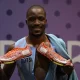 Gold medallist Botswana’s Letsile Tebogo shows his shoe to the camera reading the date of birth of his late mother as he celebrates after wining the men’s 200m final of the athletics event at the Paris 2024 Olympic Games at Stade de France in Saint-Denis, north of Paris, on August 8, 2024. (Photo by Monirul BHUIYAN / AFP)
